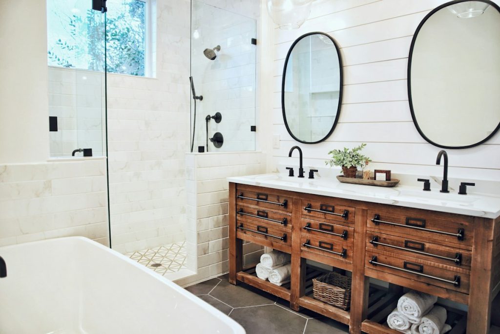 Finished bathroom with timber vanity and white bathtub