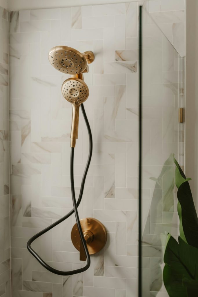 Gold handheld shower head with black hose
