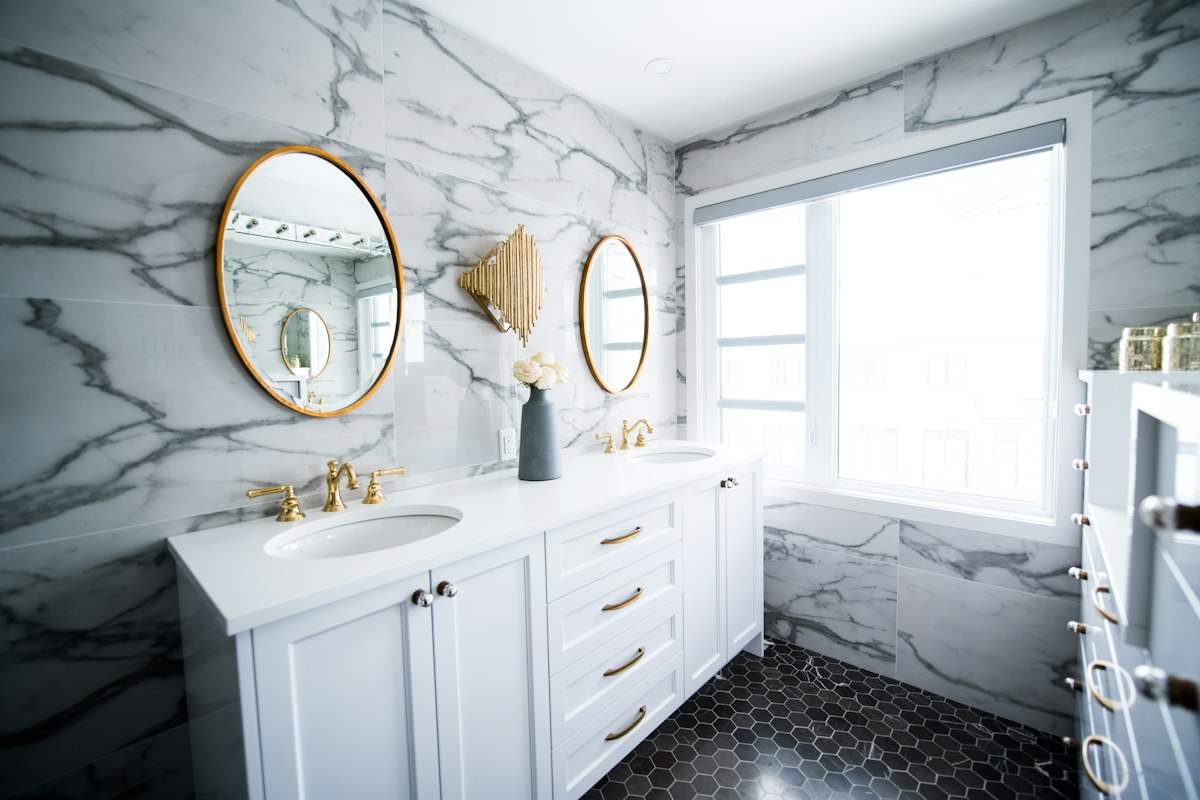 Marble bathroom with double vanity and round mirrors
