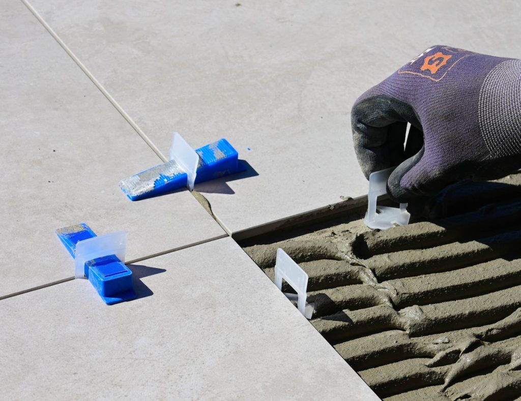 Installer fitting tile levelling clips for a flat finish