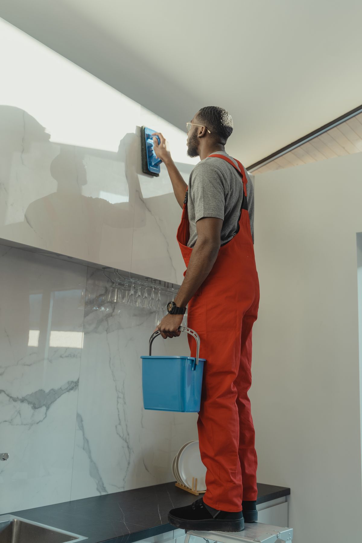 Tradesman priming a bathroom wall before tiling
