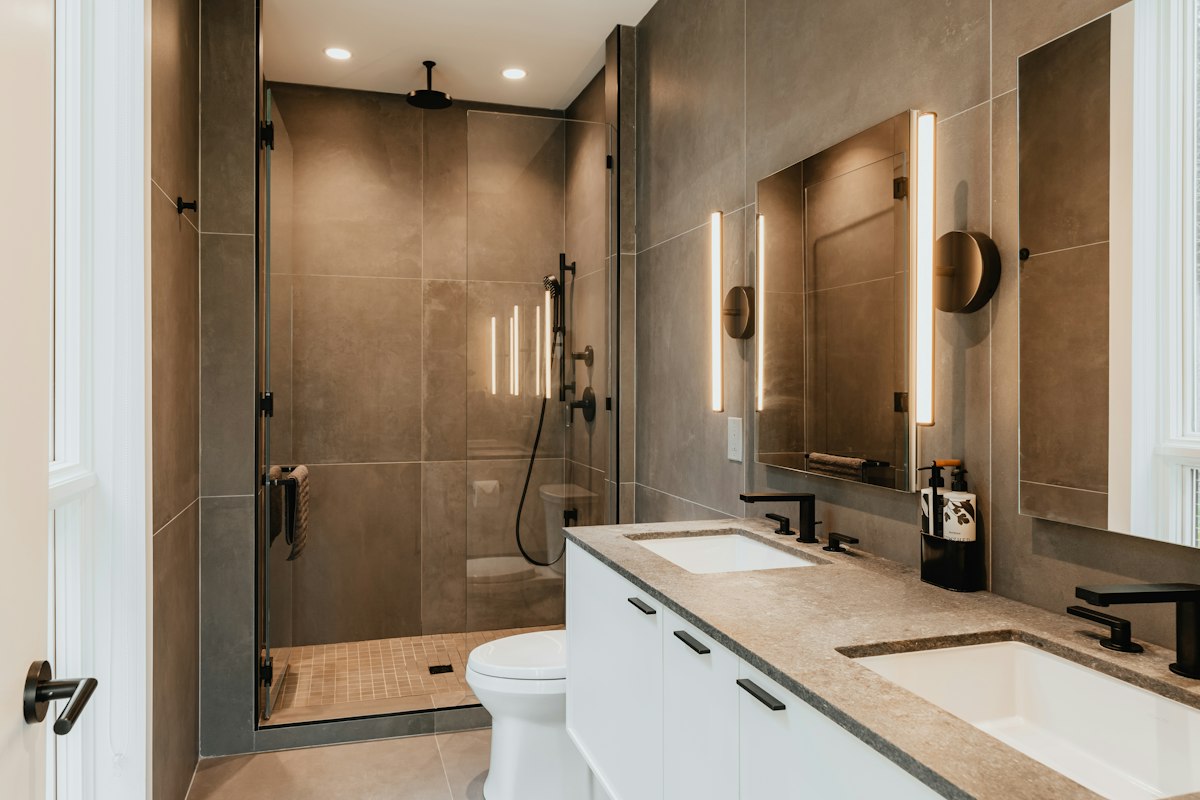 Bathroom with walk-in shower, double sink and wall-hung toilet